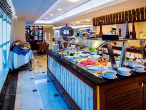 a buffet line with plates of food on display at Grand Mercure Majlis Residences in Abu Dhabi