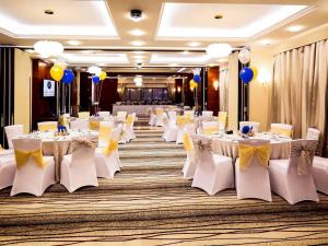 a banquet hall with white tables and chairs and balloons at Grand Mercure Majlis Residences in Abu Dhabi
