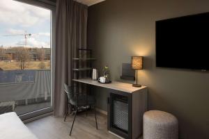 a hotel room with a desk and a large window at Scandic Vulkan in Oslo