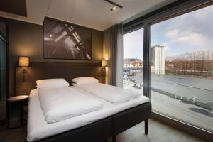 a bedroom with a bed and a large window at Scandic Vulkan in Oslo