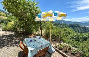 ein Tisch mit einem blau-gelben Sonnenschirm in der Unterkunft Beautiful Home In Sovramonte With Wifi in Sovramonte