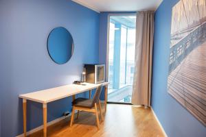 a desk in a room with a mirror and a window at Scandic Vulkan in Oslo