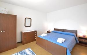 ein Schlafzimmer mit einem blauen Bett und einem Spiegel in der Unterkunft Beautiful Home In Sovramonte With Wifi in Sovramonte