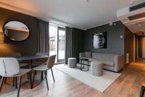 a living room with a couch and a table and chairs at Scandic Vulkan in Oslo