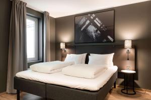 a bedroom with a large bed with white pillows at Scandic Vulkan in Oslo