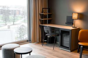 a room with a fireplace and chairs and a window at Scandic Vulkan in Oslo