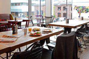 a restaurant with wooden tables and chairs with food on them at Scandic Vulkan in Oslo