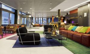 a lobby with a couch and chairs and a table at Scandic Vulkan in Oslo