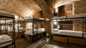 a room with several bunk beds in a brick wall at Czech Inn in Prague