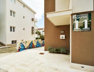 a building with a sign for a house at Apartments House Filipović in Makarska