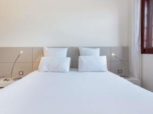 Кровать или кровати в номере Novotel Suites Perpignan Centre