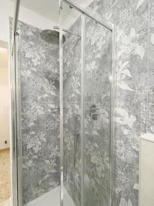 a shower in a bathroom with a floral wallpaper at La Loggia near Piazza del Campo in Siena
