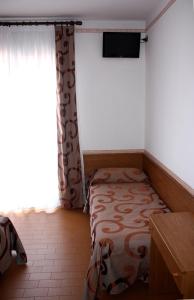 een kleine slaapkamer met een bed en een raam bij Hotel Helga in Caorle