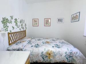 a bedroom with a bed with a floral comforter at La Loggia near Piazza del Campo in Siena