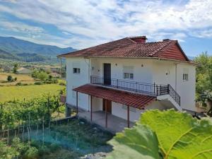 Casa blanca con balcón en un campo en NatureHouse Permet, en Përmet