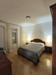 Un dormitorio con una cama y dos lámparas y una ventana. en NatureHouse Permet, en Përmet