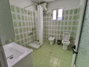 Un baño blanco con lavabo e inodoro. en NatureHouse Permet, en Përmet 3 fotos más