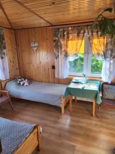 a bedroom with a bed and a table in a room at Malownicze Bieszczady - pokoje goscinne in Polańczyk