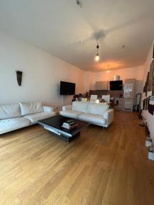 a living room with a white couch and a table at Berlin -Central-Mitte Light Filled 2BD in Niederdorla