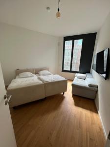 a bedroom with a bed and a couch and a window at Berlin -Central-Mitte Light Filled 2BD in Niederdorla