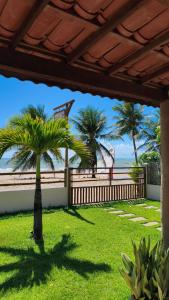 eine Palme in einem Garten neben einem Zaun in der Unterkunft Casa Maré Beach em Caetanos Ceará in Amontada