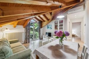 a living room with a table with flowers on it at Green Village Accommodations in Colico