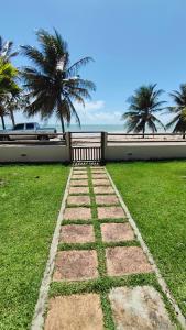 ein Steinweg vor einem Haus mit Palmen in der Unterkunft Casa Maré Beach em Caetanos Ceará in Amontada