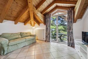 a living room with a couch and a large window at Green Village Accommodations in Colico