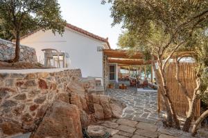 a home with a stone patio and a stone wall at SeaView Apartment 4 in Psilí Ámmos