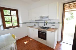 uma cozinha branca com um fogão e um lavatório em Villa Iolanda em Giarre