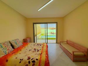 a bedroom with a bed and a view of a pool at Villa avec piscine privée hammamet bouficha in Bin Rhilouf