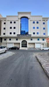 un grande edificio con auto parcheggiate di fronte di فندق ضيافة منى المشاعر الفندقية a Al Khansāk