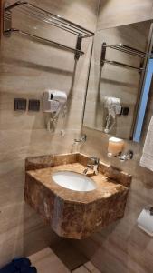 un bagno con un lavandino in marmo in una stanza di فندق ضيافة منى المشاعر الفندقية a Al Khansāk