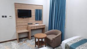 una stanza con una scrivania, una sedia e una televisione di فندق ضيافة منى المشاعر الفندقية a Al Khansāk Altre 14 foto