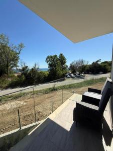 a balcony with a chair and a view of the ocean at Aurum Villas Smokinya Beach in Sozopol