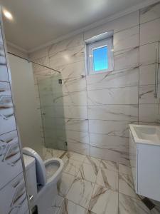 a bathroom with a toilet and a sink and a window at Aurum Villas Smokinya Beach in Sozopol +5 photos