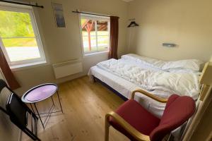 Un dormitorio con una cama y dos sillas y una ventana. en Per Gynt Lodge, en Vinstra