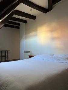 a bedroom with a white bed and wooden ceilings at Repaire de Saint-Pierre Saumur in Saumur +11 photos