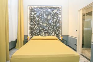 a bed in a room with a painting on the wall at Hotel Torre Orefici in Genoa