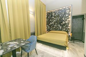 a room with a bed and a table and a table and a bed sidx sidx at Hotel Torre Orefici in Genoa