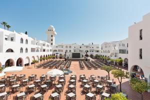 an empty courtyard of a resort with tables and chairs at Best Club Vacaciones Pueblo Indalo in Mojácar