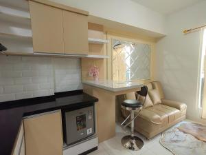a kitchen with a counter and a chair in a room at Podomoro Golf View By Arsakha Property Management in Tjikuda Tiga