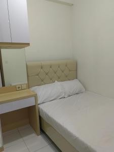a small bedroom with a bed and a table at Podomoro Golf View By Arsakha Property Management in Tjikuda Tiga