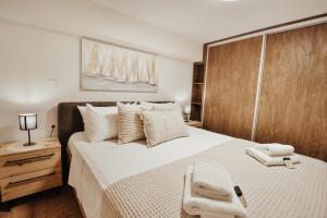 une chambre avec un grand lit avec des serviettes dessus dans l'établissement Corfu Luxury Lofts by Corfuescapes, à Corfou