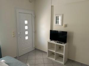 a room with a television on a stand with a door at Emerald Studio in Límni
