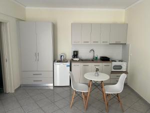 a kitchen with a table and chairs and a white refrigerator at Emerald Studio in Límni