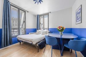 Un dormitorio con una cama y una mesa con sillas. en City Center l 15min from Eiffel Tower by Car, en Boulogne-Billancourt