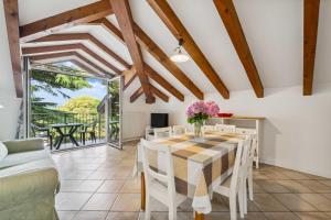 a dining room with a table and chairs and a couch at Green Village Accommodations in Colico