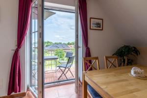 a dining room with a door open to a balcony at Ferienwohnung Katharina OG in Wohlenberg