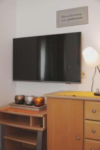 a flat screen tv on a wall above a wooden table at Ferienhaus Ahorn in Neustift im Stubaital